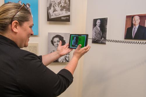 Visitor using the LAL's Augmented Reality app at the Pan-American Life in New Orleans Exhibit Opening, 2019.